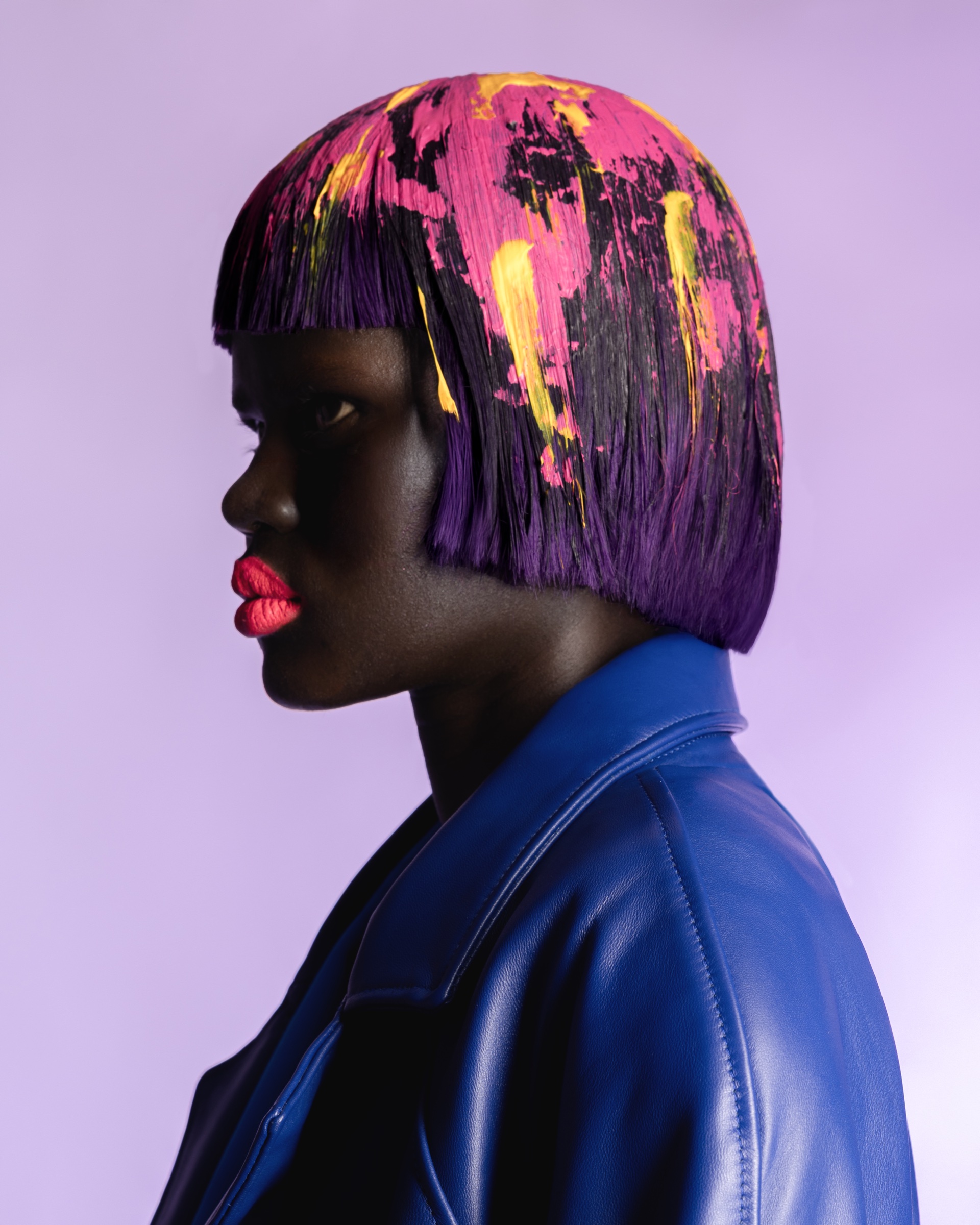 Profile portrait with a painted purple bob and blue jacket, Expressive editorial by Jae Eun Seok